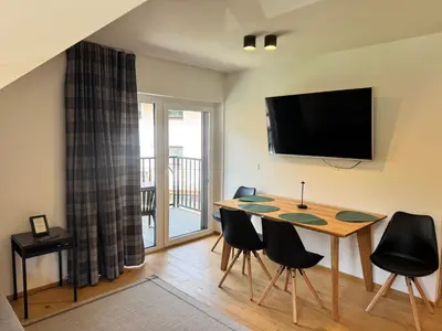 a dining room with a table and chairs and a television at Apartmaji Kotnik in Kranjska Gora