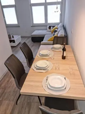 a dining room with a wooden table and chairs at APARTMA KAAN in Žaga