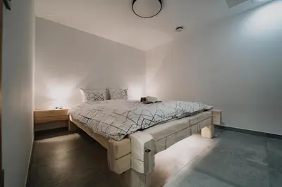 a bedroom with a bed in a white wall at Koča Žafran - Velika planina in Stahovica
