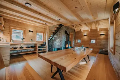 a dining room with a wooden table in a log cabin at Koča Žafran - Velika planina in Stahovica