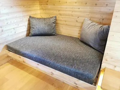 a bed in a log cabin with two pillows at Koča Žafran - Velika planina in Stahovica
