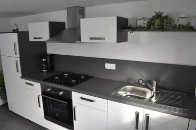 a kitchen with white cabinets and a sink at Apartma VRBA Dobrna in Dobrna