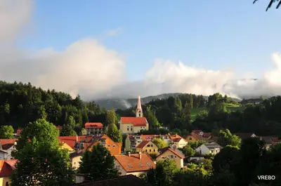 a town on a hill with clouds in the background at Apartma VRBA Dobrna in Dobrna