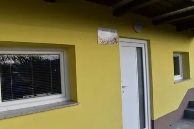 a yellow building with a window and a door at Apartma VRBA Dobrna in Dobrna