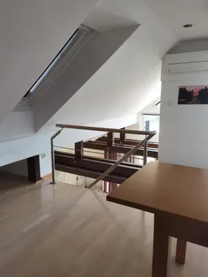 a living room with a wooden table and stairs at BALCON Apartments in Bled