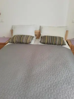 a bed with two pillows on top of it at BALCON Apartments in Bled