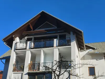 a white building with balconies and a roof at BALCON Apartments in Bled