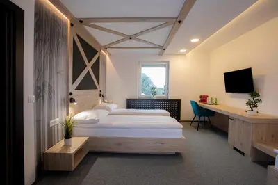 a bedroom with a bed and a desk and a television at Rooms Bolero Naklo in Naklo