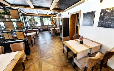 a dining room with wooden tables and chairs at Rooms Bolero Naklo in Naklo