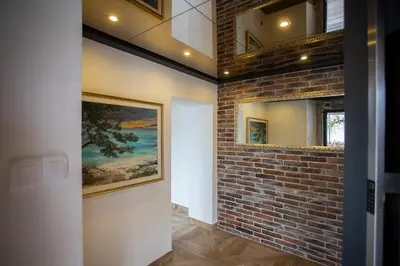 a hallway with a brick wall and a painting on a wall at Rooms Bolero Naklo in Naklo