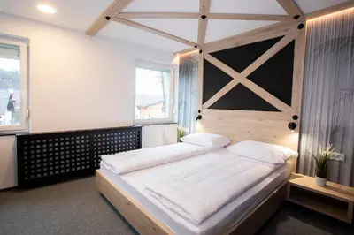 a bedroom with a large bed with a wooden headboard at Rooms Bolero Naklo in Naklo