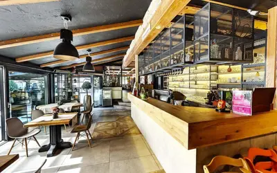 a restaurant with a bar with tables and chairs at Rooms Bolero Naklo in Naklo