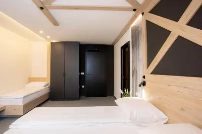 a bedroom with two beds and a black door at Rooms Bolero Naklo in Naklo