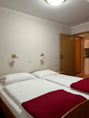a bedroom with two beds with white and red sheets at Apartma Anastasija in Kranjska Gora