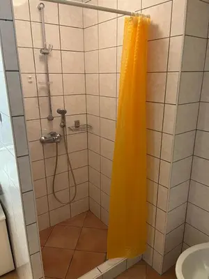 a shower with a yellow shower curtain in a bathroom at Apartma Anastasija in Kranjska Gora