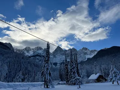 a snow covered mountain with trees and a ski lift at Apartma Anastasija in Kranjska Gora