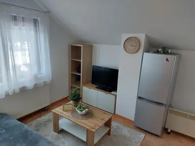 a living room with a refrigerator and a table at Apartma Anastasija in Kranjska Gora