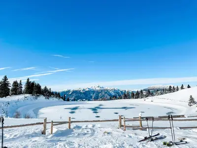 a view of a snow covered slope with skis and a fence at Sunshine Apartments Golte - Sauna in Mozirje