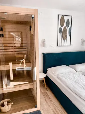 a bedroom with a bed and a glass door at Sunshine Apartments Golte - Sauna in Mozirje