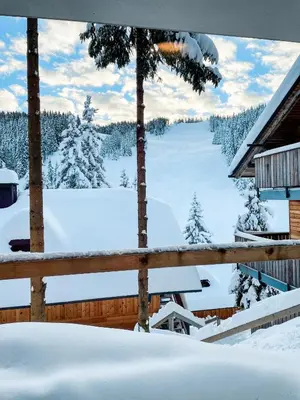 a view from the deck of a cabin in the snow at Sunshine Apartments Golte - Sauna in Mozirje