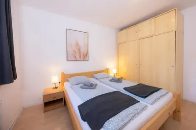 a bedroom with a large bed with a wooden headboard at Apartmaji Anže Kranjska Gora in Kranjska Gora