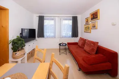 a living room with a red couch and a table at Apartmaji Anže Kranjska Gora in Kranjska Gora
