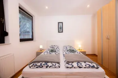 a bed in a room with two lamps and a window at Apartmaji Anže Kranjska Gora in Kranjska Gora
