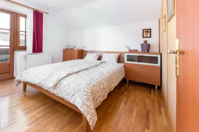 a bedroom with a bed and a wooden floor at Hiša nasproti sonca in Kranjska Gora