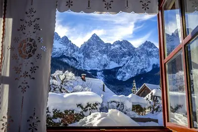 a window with a view of a snow covered mountain at Hiša nasproti sonca in Kranjska Gora