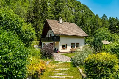 a white house with a pathway leading to it at Hiša nasproti sonca in Kranjska Gora