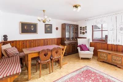 a dining room with a table and a couch at Hiša nasproti sonca in Kranjska Gora