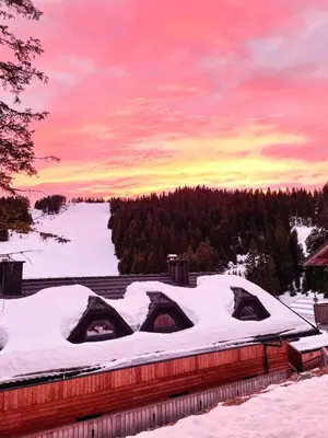 a snow covered roof of a house with tents at Sunshine Apartments Golte COMFORT in Mozirje