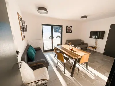 a living room with a table and a couch at Sunshine Apartments Golte COMFORT in Mozirje