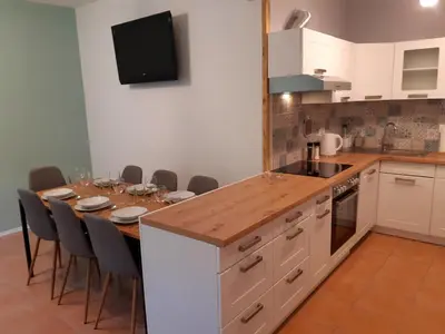 a kitchen with a table with chairs around it at SočaLand Apartmaji in Soča