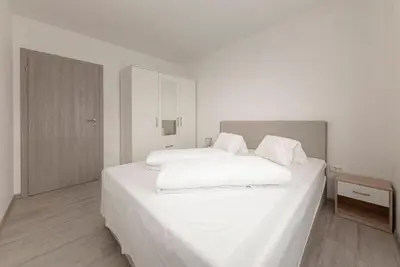 a white bedroom with two beds with white sheets at Perfect Place Apartments in Kranj