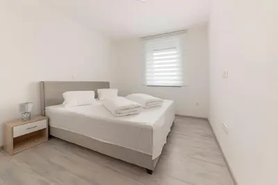 a white bedroom with a bed and a window at Perfect Place Apartments in Kranj