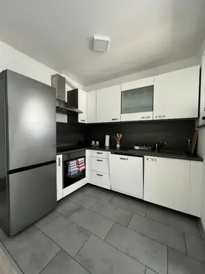 a kitchen with white cabinets and a stainless steel refrigerator at Perfect Place Apartments in Kranj