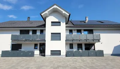 a white building with a balcony and a roof at Perfect Place Apartments in Kranj