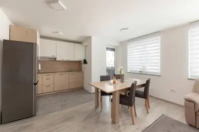 a kitchen and dining room with a table and a refrigerator at Perfect Place Apartments in Kranj