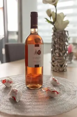 a bottle of wine sitting on a table with candy at Perfect Place Apartments in Kranj
