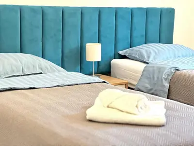 a bed with a folded towel on top of it at All Seasons Apartments Laško in Laško