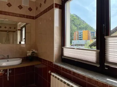 a bathroom with a sink and a window at All Seasons Apartments Laško in Laško