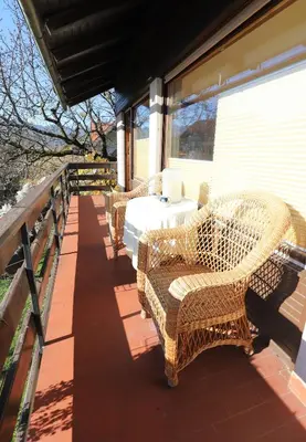 a porch with wicker chairs and a table on a balcony at Vintage Apartment Bled in Bled