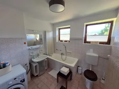 a white bathroom with a tub and a sink at Vintage Apartment Bled in Bled