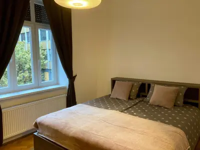 a bedroom with a bed and a window at Twix rooms in Ljubljana