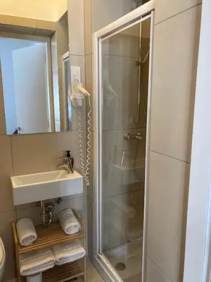 a bathroom with a shower and a sink at Twix rooms in Ljubljana