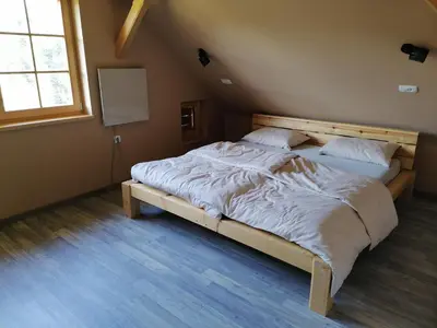 a bedroom with a large bed with white sheets at Cottage Golenovo in Podvelka