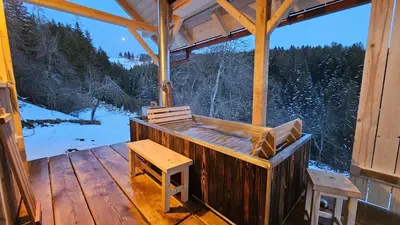 a porch of a cabin with a bench and a table at Cottage Golenovo in Podvelka