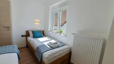 a small bedroom with a bed and a window at Apartments Seventy Seven in Kranjska Gora
