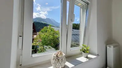 an open window with a view of a mountain at Apartments Seventy Seven in Kranjska Gora